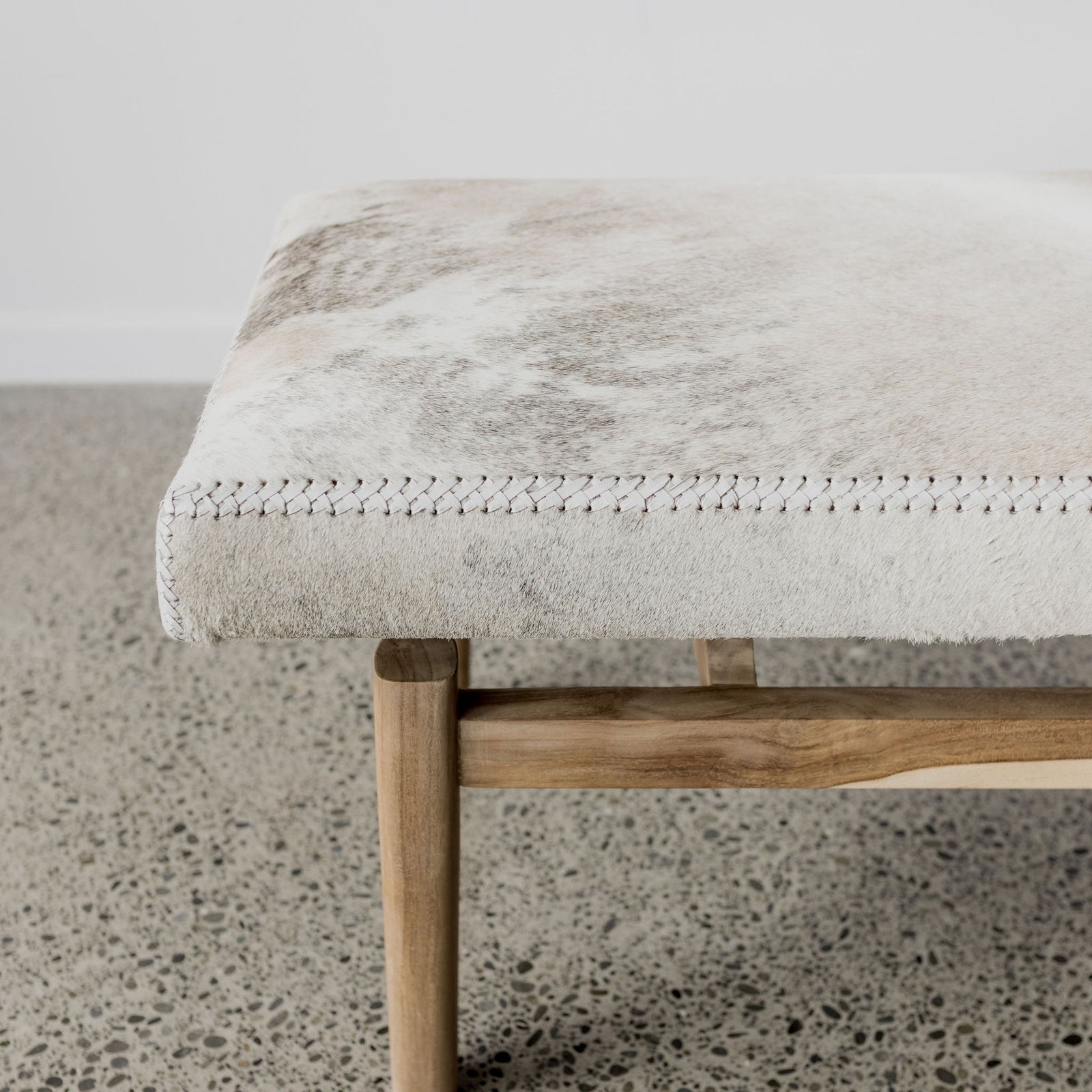 close up of a hide bench seat for foot of bed bench