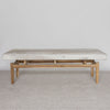 front view of a Corcovado large creamy white cowhide bench seat on a teak wood base.