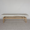 front view of a wide cowhide ottoman bench that can be used as a bedroom bench or an entry bench on a teak wood base