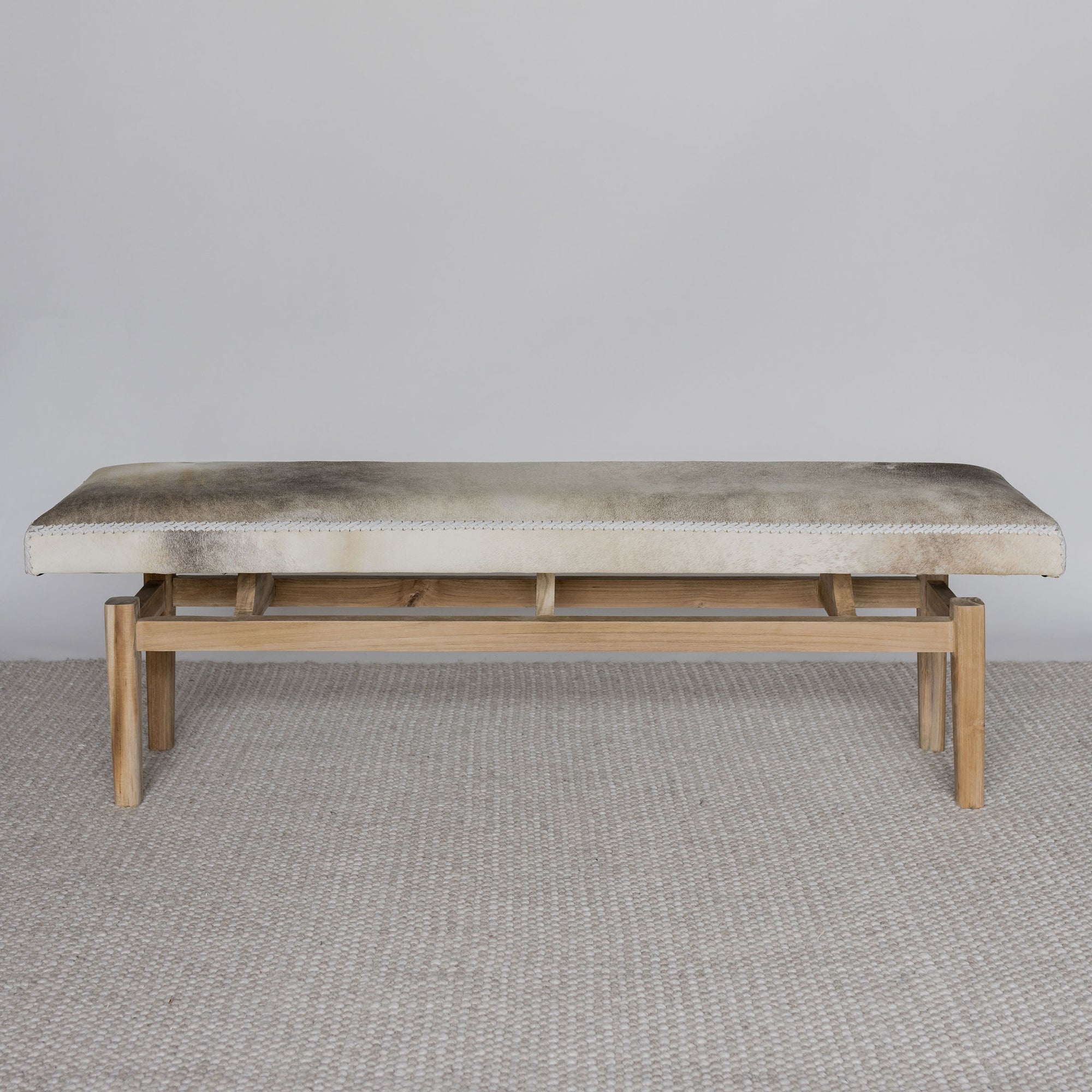 Hide bench seat in cream and gray tones by Corcovado Design