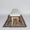 the end view highlighting the depth of a Corcovado Design creamy white cowhide bench seat with wooden legs on a vintage turkish rug