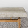 close up view of Corcovado Design's cowhide ottoman bench which featuring cream and gray tones on top and a solid teak wood base