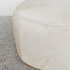 close up of the leather stitching on the light cream colored hair on hide ottoman from corcovado designs