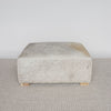 square hide ottoman with gray and caramel tones