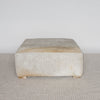 square hide ottoman with gray and caramel tones