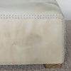 close up showing the leather handstitched detail on the caramel brown and creamy colored square hide ottoman coffee table