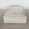 showing the top view of a light cream colored square hide ottoman coffee table