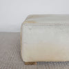 close up angle of the light creamy colored square hide ottoman coffee table