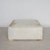 light colored square hair on hide ottoman coffee table with small teak wood feet