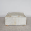 light colored square hair on hide ottoman coffee table with small teak wood feet