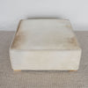 top view of the light colored square hair on hide ottoman coffee table with small teak wood feet