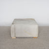 square cowhide ottoman coffee table in light tones with small teak wood feet