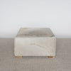 square cowhide ottoman coffee table in light tones with small teak wood feet