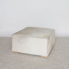 angled view of the square cowhide coffee table ottoman in earthy tones and gray by corcovado design