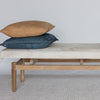 front view of a dark gray colored hide bench seat from corcovado designs together with 2 earthy colored cushions