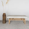 cream and gray colored hide ottoman bench by Corcovado next to a vintage brown woven tall basket