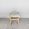 end view of a cream and gray colored hide ottoman bench by Corcovado