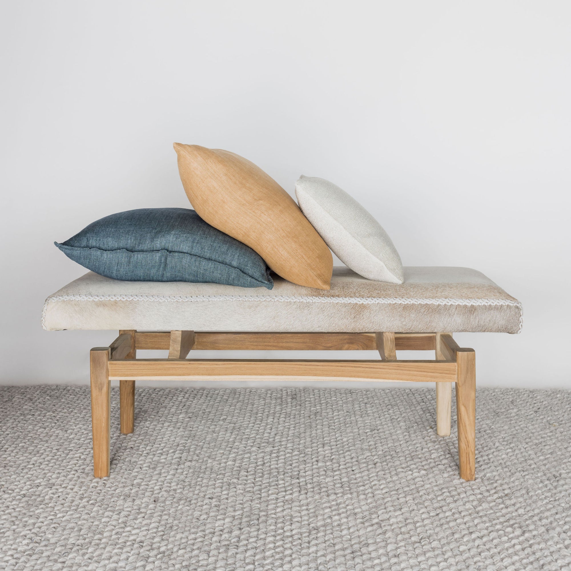 front view with 3 cushions on top of a  an earthy cream colored cowhide bench seat from corcovado 