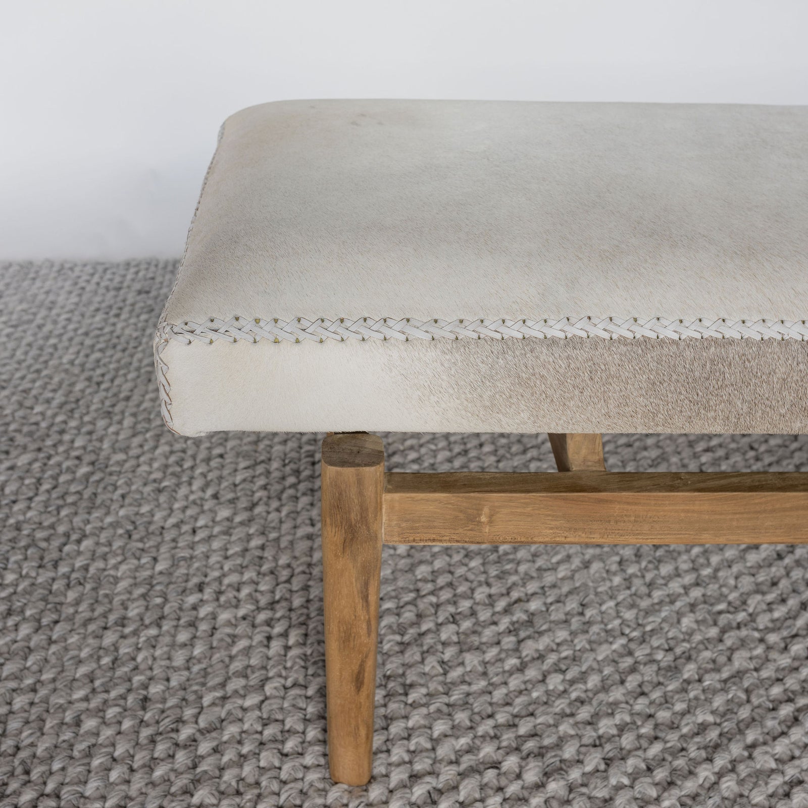 close up view of a cream colored light cowhide ottoman bench seat from Corcovado Designs 