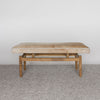 front view of a caramel and cream colored hair on hide bench seat for entry or bedroom bench