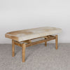 angled view of a caramel and cream colored hair on hide bench seat for entry or bedroom bench