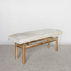 angled view of a light cream colored hide ottoman bench