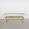 front view of a light cream colored hide ottoman bench