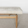 end view of a light cream colored hide ottoman bench