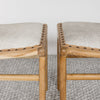 close up view of the pair of small cowhide bench seat stools with white and grey hide