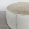 close up view of extra large cowhide round ottoman in light colored tones