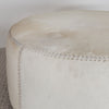 close up of front view of a light colored hair on hide round ottoman coffee table by corcovado design