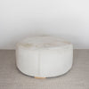 front view of a light colored hair on hide round ottoman coffee table by corcovado design