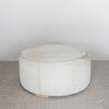 front view of a light colored hair on hide round ottoman coffee table by corcovado design