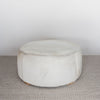 front view of a light colored hair on hide round ottoman coffee table by corcovado design