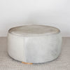 natural toned round hide footstool with leather stitching