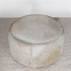 top view photo of the natural toned round hide footstool with leather stitching