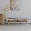 hair on  Hide bench seat in cream and earthy tones under an art work and next to an oversized pot