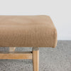 detailed view of the fabric on the end of the  earthy tobacco colored upholstered bench seat