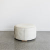 cream colored light round cowhide ottoman coffee table