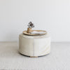 round cowhide ottoman coffee table with a natural rattan tray on top