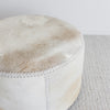 close up of the top of the brown and cream round cowhide ottoman coffee table