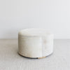 side view of the creamy light toned cowhide ottoman coffee table