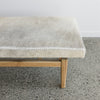 close up view of the hide on the cowhide bench seat ottoman from corcovado with shades of cream and grey on the top of the hide