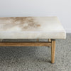 close up of the brown and cream cowhide bench seat ottoman for a window seat