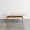 front view  of the brown and cream colored cow hide bench seat ottoman