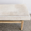 close up view of the hide on the cream coloured hair on hide bench seat ottoman