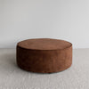 low, round velvet ottoman in a cinnamon color from corcovado