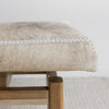 detailed view of the end of the hair on hide ottoman bench seat on wooden base