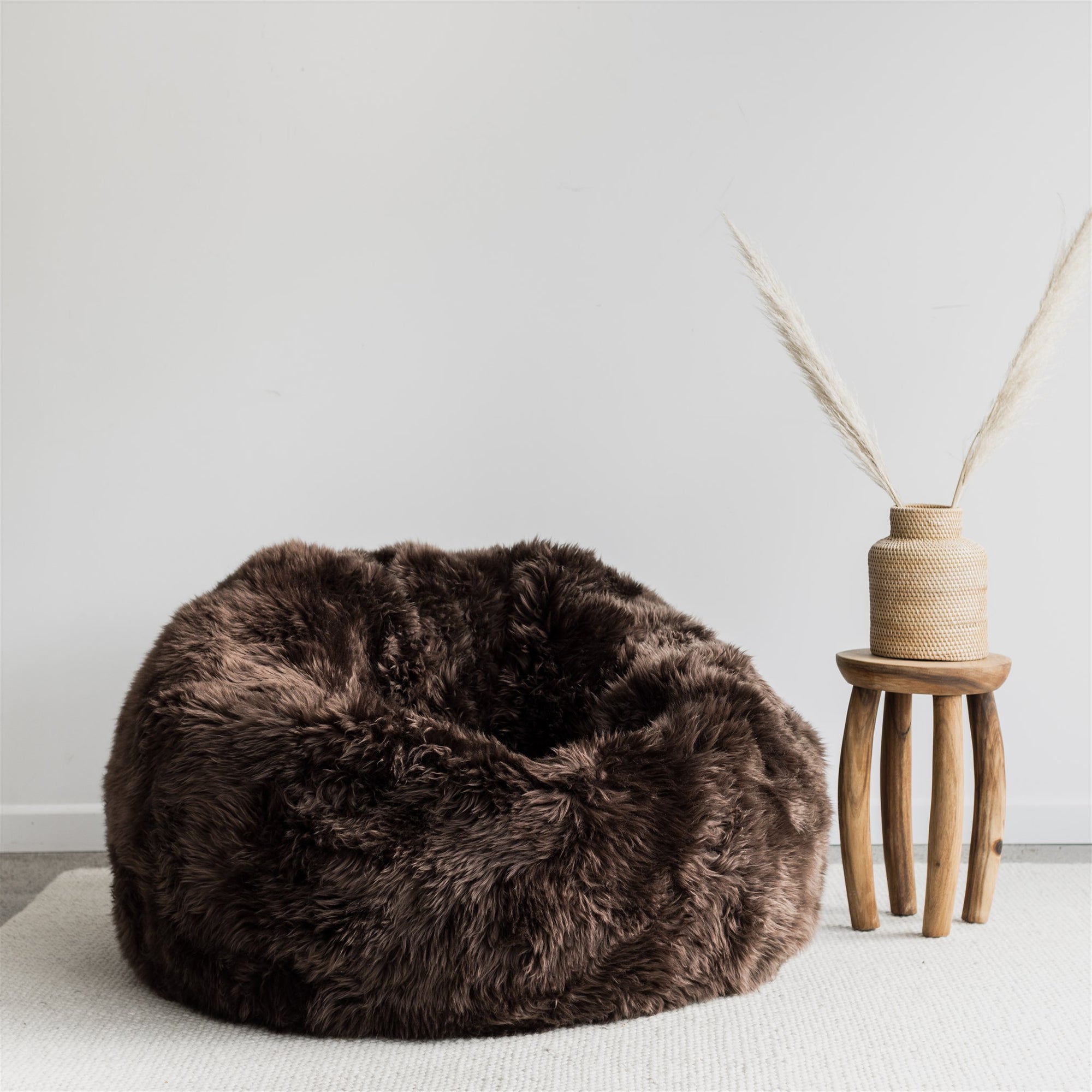 dark brown sheepskin beanbag chair with small wooden side table 