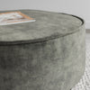 close up of the piped edging on the round ottoman in green velvet